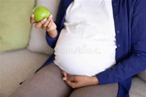 Millennial Black Lady With Big Belly Enjoys Pregnancy Hold Green Apple