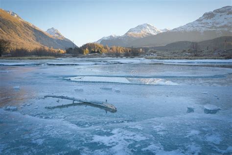 Beautiful Shot Of Frozen Water Surrounded By Trees And Mountains With A