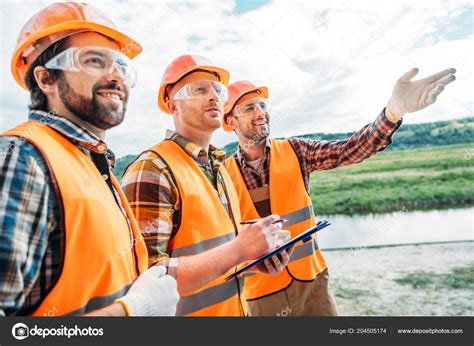 Group Builders Hard Hats Reflective Vests Pointing Somewhere — Stock