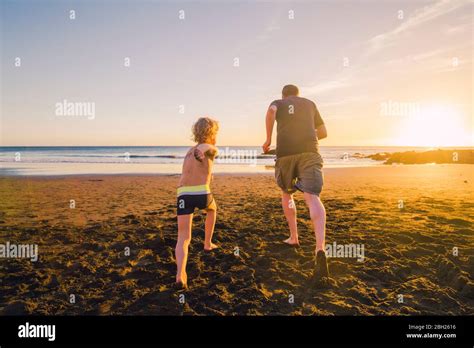 Father And Son Running On The Beach Rear View Stock Photo Alamy