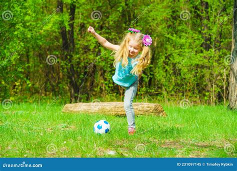 Une Petite Fille Mignonne Joue Avec Un Ballon Sur Un Pré Vert Image