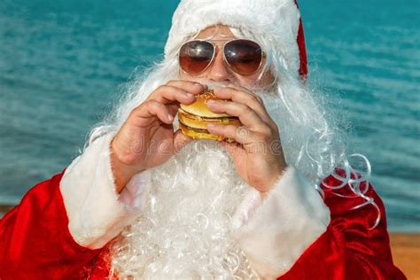 Santa Claus On The Beach Eating A Hamburger Stock Image Image Of