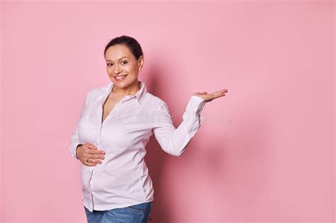 Happy Pregnant Woman Touching Gently Her Belly Smiling At Camera Holding Imaginary Copy Ad