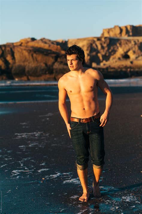 Man Walking On Beach During Sunset With No Shirt By Stocksy Contributor Melanie Riccardi