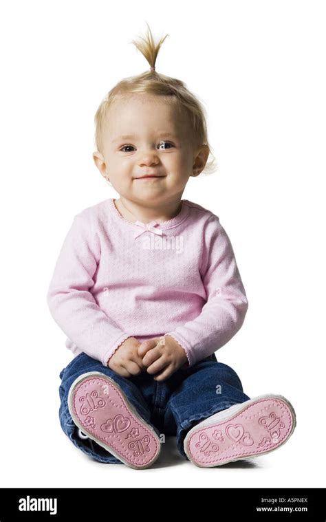 Baby Girl With Ponytail Sitting And Smiling Stock Photo Alamy