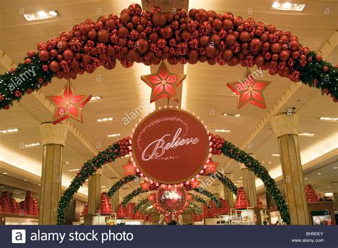 He is holding a candle that has a light. The Macy's Christmas Believe store decorations Stock Photo ...