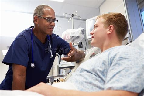 Young Male Patient Talking To Male Nurse In Emergency Room Stock Image