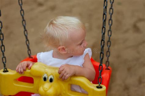 Cute Blond Baby Girl Sitting In A Swing Stock Image Image Of
