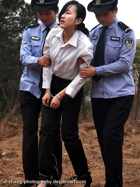woman in handcuffs and leg irons attended by female chinese police officers reenactment