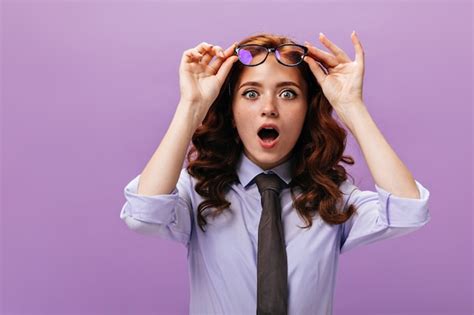 Free Photo Shocked Lady Takes Off Her Eyeglasses On Purple Wall