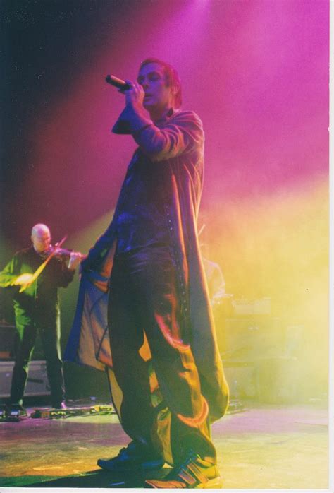 A Man Standing On Top Of A Stage Holding A Microphone