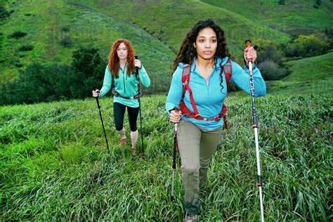 Serious women hiking with walking sticks - Stock Photo - Dissolve