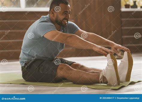 Young Happy Smiling Fitness Man Doing Stretching Exercises At Home