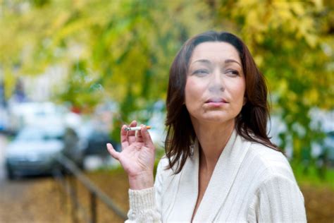 Attractive Mature Woman Smoking Outside Stock Photo Download Image