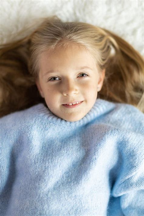 Cute Little Caucasian Girl Seven Years Old With Blonde Hair Lying On