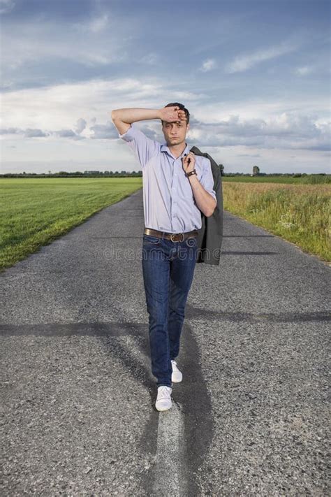 Full Length Of Tired Young Man Walking Alone On Rural Road Stock Image