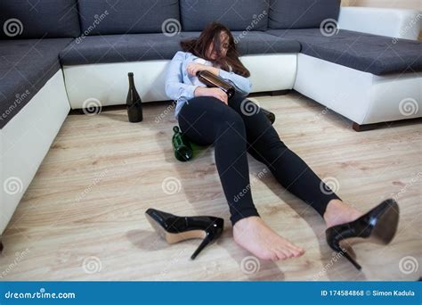 Drunk Woman Laying On The Floor After Huge Party With Some Bottles Of Wine Alcoholism Concept