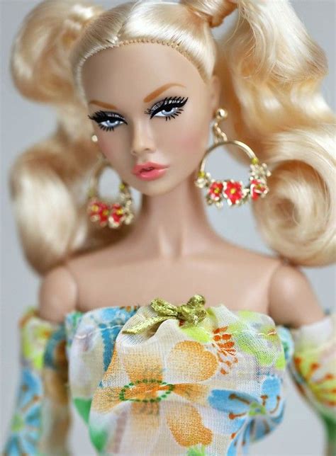 a barbie doll with blonde hair and big hoop earrings on her head wearing a floral dress