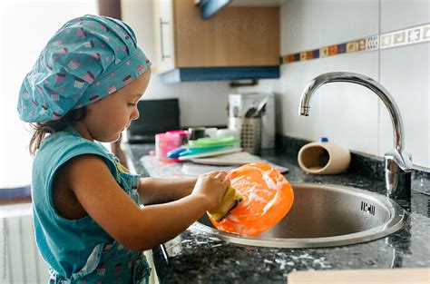 Little Girl Washing Dishes By Stocksy Contributor Marco Govel Stocksy