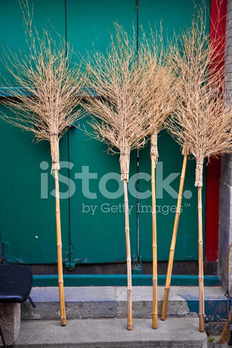 Traditional Chinese Brooms Leaning Against Wooden Door Stock Photo