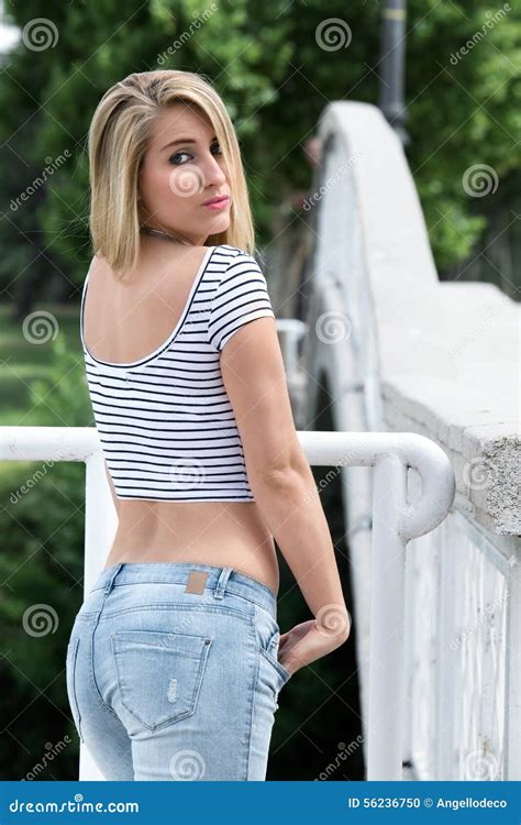 Portrait Of Casual Woman Looking Back Next To Bridge Royalty Free Stock