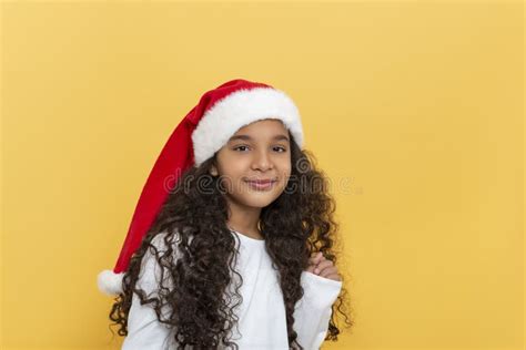 Studio Shor Of Dark Skinned Young Girl With Long Curly Hair In A Santa