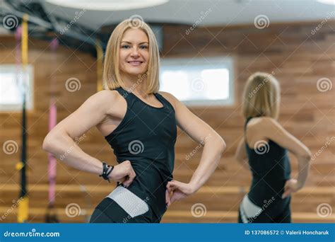 Portrait Of Adult Blonde Fitness Woman Personal Trainer In Gym