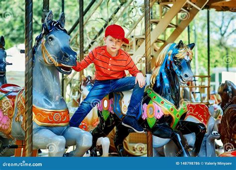 Beautiful Boy Posing On The Carousel A Child In The City Park On The