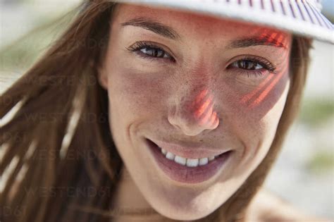 Portrait Of Smiling Young Woman Wearing Sun Visor Stock Photo