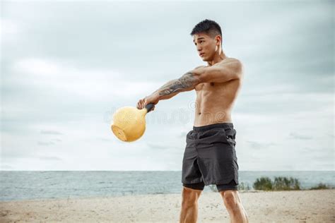 Young Healthy Man Athlete Doing Squats At The Beach Stock Photo Image