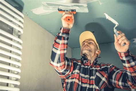 Premium Photo Construction Worker Patching Bathroom Ceiling