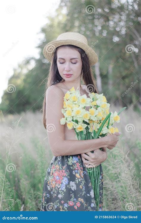 Topless Brunette Woman In Straw Hat Covering Her Breasts With Flowers