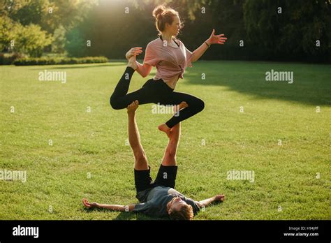 Man And Woman Doing Various Yoga Poses In Pair Outdoors Fit Couple