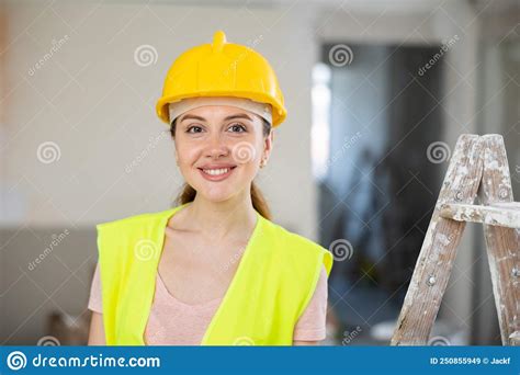 Portrait Of Positive Builder Woman In Yellow Vest And Safety Helmet