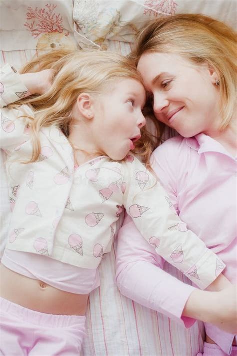 mère et fille se trouvant sur le lit dans des pyjamas roses photo stock image du fille blanc