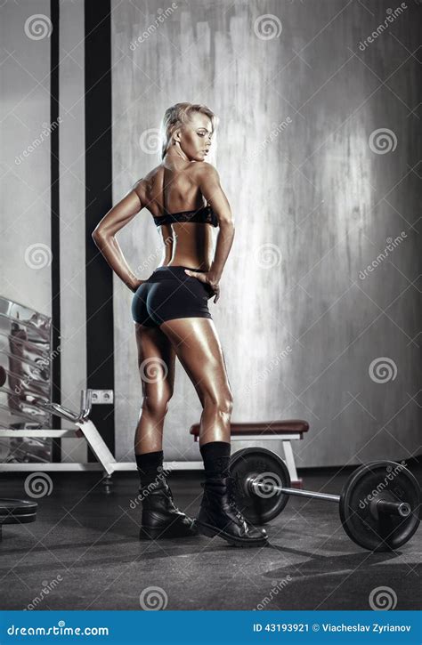 Fitness Blonde Girl Prepares For Exercising With Barbell In Gym Stock