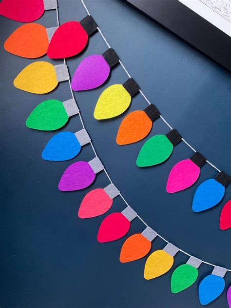 Colorful Paper Christmas Lights Are Hanging From A String