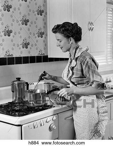 1950S Housewife In Apron Stirring Food In Saucepan On Stove Picture