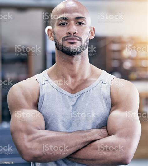 Portrait Of A Muscular Young Man Standing With His Arms Crossed In A