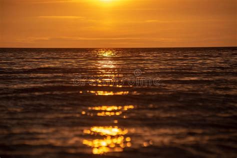 Colorful Sunset Over Calm Sea Beach With Dark Blue Water And Dramatic