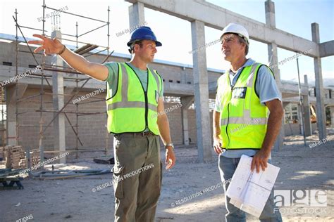 Caucasian Construction Workers Talking At Construction Site Stock