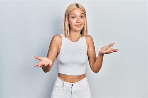 Beautiful Blonde Woman Wearing Casual Style With Sleeveless Shirt Clueless And Confused