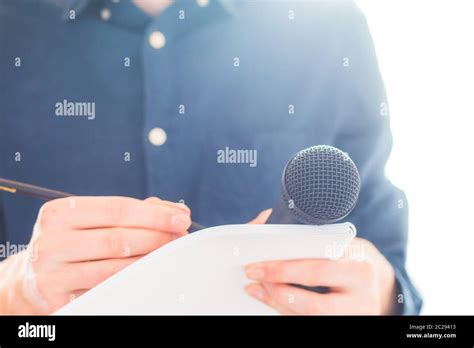 Male Journalist At News Conference Holding Microphone And Taking Notes