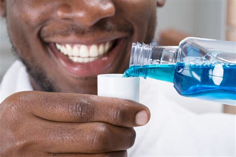Close Up Of A Man Pouring Mouthwash Into Cap Creekview Dental
