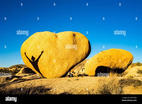 Heart Shaped Boulder With Shadow Of Man With Arms Outstretched In