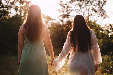 Back View Of Lesbian Couple Holding Hands While Standing In Forest Photograph By Cavan Images