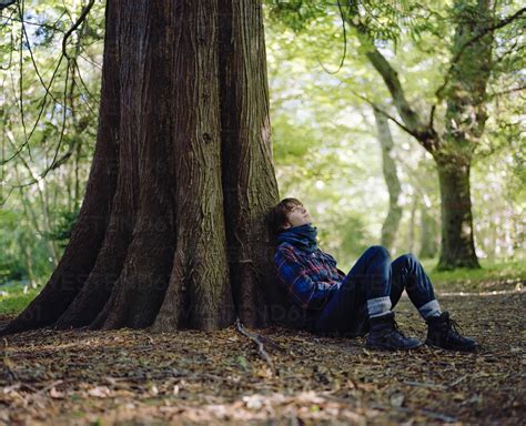 Woman Sitting Under Tree Stock Photo