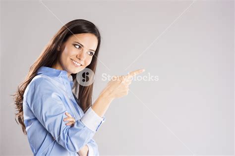 Beautiful Young Woman Pointing To Somewhere Isolated Over A White