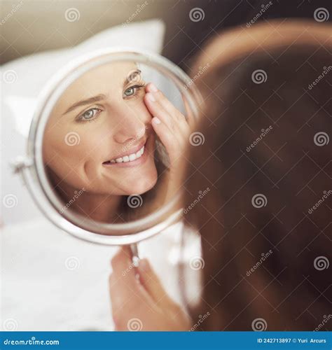 Having A Great Skin Day Shot Of An Attractive Young Woman Admiring Herself In A Mirror Stock