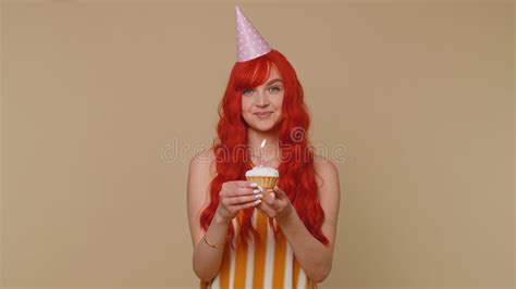 Happy Redhead Girl Celebrating Birthday Anniversary Party Blowing Candle On Small Cake Cupcake